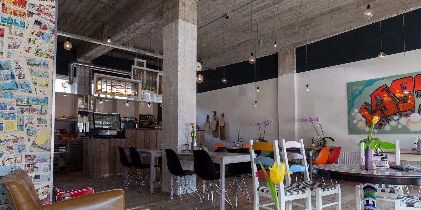 De lichte lunchroom met strips op de pilaar en graffiti aan de muur